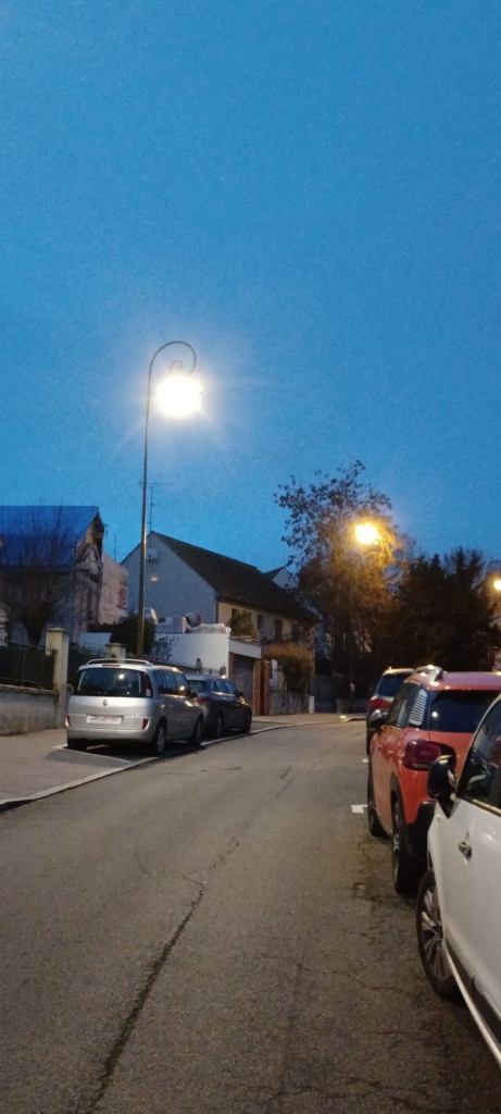 Eclairage de la rue Hélène-Andrée à Versailles (France), o les lampes à vapeur de sodium donnant un éclairage jaune (lanterne de droite) ont été remplacées par des lanternes à LED, donnant un éclairage type lumière du jour (lanterne de gauche).